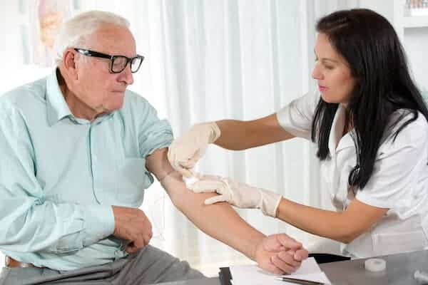 Phlebotomist Drawing Blood From Senior